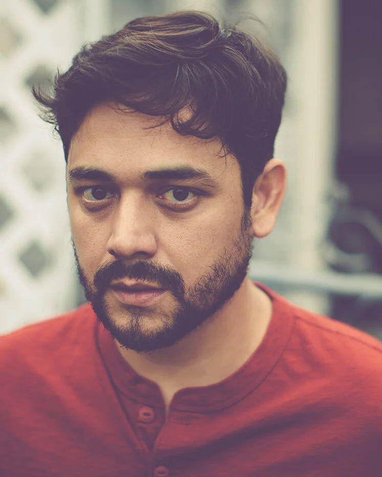 Close portrait of Sol Navarro in a red henley